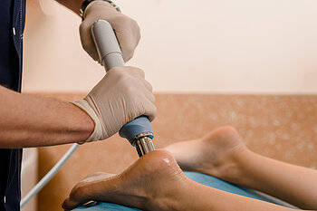 Physical therapy of foot with acoustic shock waves, closeup photo